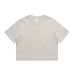 A light beige cropped t-shirt featuring short sleeves and a round neckline. The shirt has a simple design and a logo.