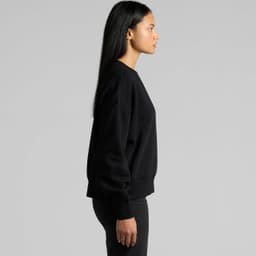 A black crew jumper is displayed on a model, highlighting its simple design and relaxed fit from the side.