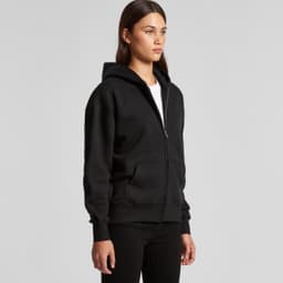 A black zip-up hoodie worn by a model, featuring a hood and front pockets. The hoodie has a logo.