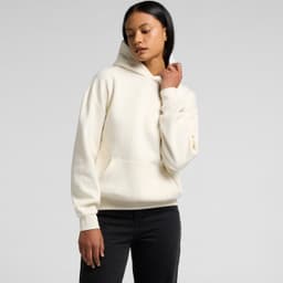 A cream hoodie with a front pocket and a hood, worn by a model against a plain background.