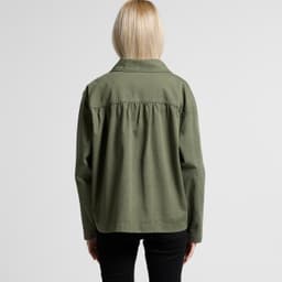 A green chore jacket viewed from the back, featuring a relaxed fit and a collar. The model has long blonde hair.