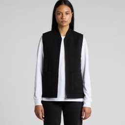 A black heavy vest with two front pockets, worn over a white long-sleeve top. Features branding.