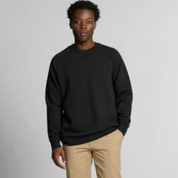 A black jumper sweater worn by a man, featuring a simple design and a logo on the chest.
