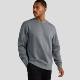 A grey crew jumper worn by a man with a moustache, featuring long sleeves and a relaxed fit.