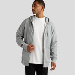 A grey zip hoodie is worn by a man over a plain white t-shirt, featuring a hood and a front zip.