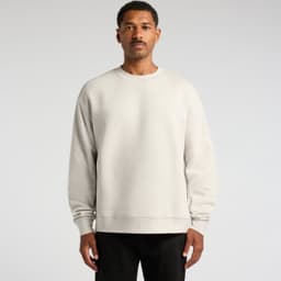 A light grey sweater on a man, featuring a relaxed fit and long sleeves. The garment has a logo on it.