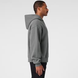 A grey jumper with a hood, displayed from the side. Features a logo on the garment.