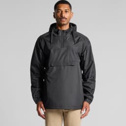 A man wearing a black windbreaker jacket featuring a hood and front pocket. The jacket has a logo on it.