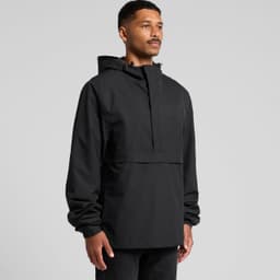 A black tech windbreaker jacket featuring a hood and a front pocket, worn by a man standing against a plain background.
