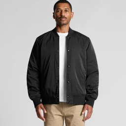 A man wearing a black bomber jacket with a front snap closure and ribbed cuffs, posing against a neutral background.