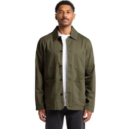 A man wearing an olive green Chore Jacket with multiple pockets and a logo. The jacket has a classic collar and button front.