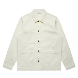 A light cream canvas chore jacket with button closures and multiple pockets, featuring a brand logo.