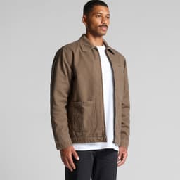 A brown canvas heavy jacket featuring two front pockets and a logo, worn by a model against a neutral backdrop.