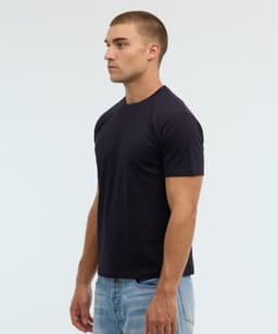 A navy blue essential tee displayed on a male model, featuring a fitted style and simple design.