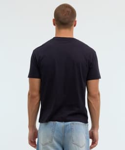 A black t-shirt with short sleeves, displayed from the back, paired with light blue jeans. The shirt features a logo.
