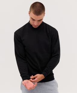 A black crew jumper is worn by a model standing against a light background, with single colour and a subtle logo.