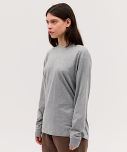 A long sleeve grey T-shirt with a relaxed fit, featuring a subtle branding detail.