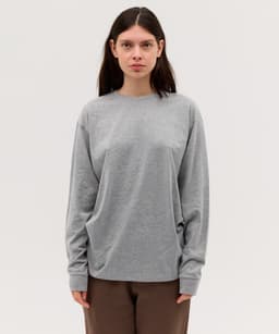 A long sleeve grey tee shirt with a relaxed fit, featuring a logo on the front.