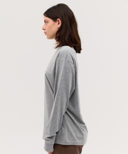 A long sleeve tee in a soft grey colour, featuring a relaxed fit and a subtle logo.