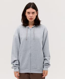 A grey zip-up hoodie with a relaxed fit, featuring a hood and two front pockets. It has a logo on it.