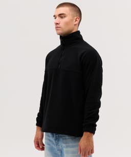 A black Everest Polar Fleece 1/4 Zip jacket on a model, featuring a high collar and long sleeves.