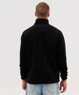 A man is wearing a black Everest Polar Fleece 1/4 zip jacket, viewed from the back. The jacket features a high collar.