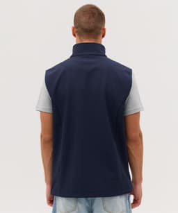 A navy softshell vest with a high collar, featuring a logo, viewed from the back.