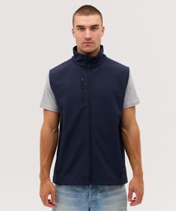 A navy softshell vest with a high collar, featuring a zip pocket and paired with a light grey T-shirt.