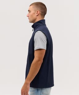 A navy softshell vest with a high collar, featuring a fitted design and a logo on the chest.