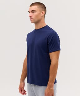 A navy blue t-shirt displayed on a model, featuring a simple design and a logo.