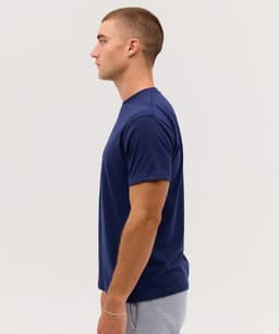 A navy blue T-shirt displayed on a model, shown from the side. The shirt has a simple design and includes a logo.