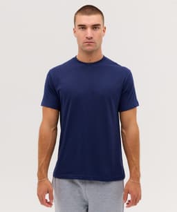 A navy T-shirt displayed on a model, featuring a simple design and short sleeves. The model has short hair and a neutral expression.