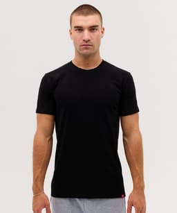 A black short-sleeved T-shirt displayed on a model, featuring a subtle logo at the hem.