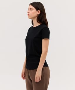 A black women's essential tee with short sleeves and a round neckline, displayed on a model in a neutral setting.