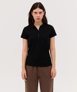 A black women's polo shirt with a collared neckline and button details, displayed on a model.