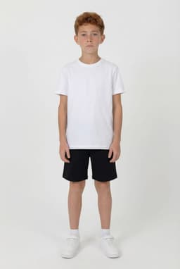 A boy wearing a white t-shirt and black sports shorts, standing on a plain background. The shorts have a logo.