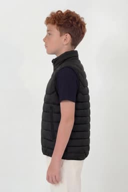 A black puffer vest with a quilted design, displayed on a child in profile view against a plain background.