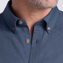 Men's button-up shirt in a dark blue colour with a collar and button details. Features a logo on the fabric.