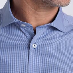 A close-up of a men's button-up shirt featuring a blue check pattern and a collar with a logo.