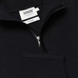 A navy Merino shirt with a zip neck and front pocket, featuring a brand label inside.