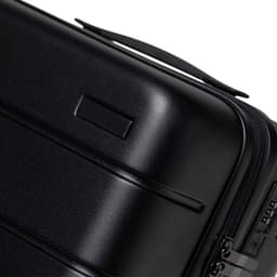 A black hardcase trolley with a smooth finish and a handle, featuring a zip closure and a small branding area.