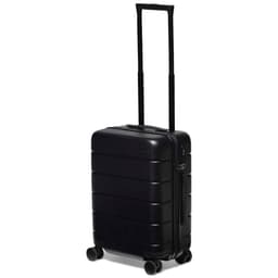 A black hardcase trolley with a telescopic handle and four wheels, featuring a logo on the front.