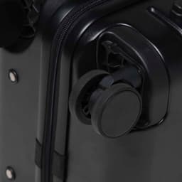 A close-up of a black hardcase trolley with a wheel and zipper detail. The product features a logo.
