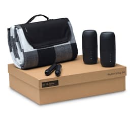 A black and white checkered blanket, two black speakers, and two black markers on a brown box.