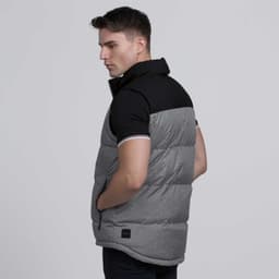 A man wearing a grey and black sleeveless vest with a high collar, featuring a logo on the side.