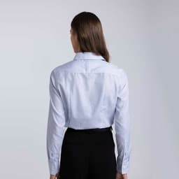 A women's button-up check shirt in light blue with long sleeves and a fitted style, featuring a logo.