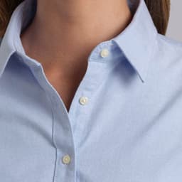 A light blue button-up shirt with a collar and two buttons at the neckline, featuring a logo on the chest.
