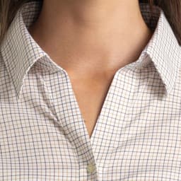 A close-up of a women's button-up shirt featuring a check pattern in light colours and a collar.