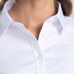 A white button-up shirt for women, featuring a collared neckline and a subtle branding detail.