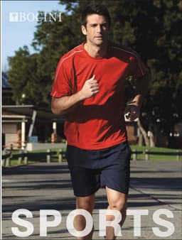 A man in a red round neck t-shirt jogs outdoors, wearing navy shorts. The shirt features a logo.